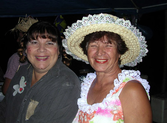 DSCN1105.jpg - Eneida e Maura arrasando nos quitutes: milho cozido, canjica, bolo de tapioca, roti dogui e muito quentão