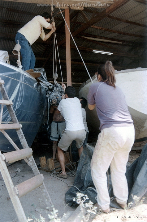 Const103.jpg - Na hora de subir o motor, sob a coordenao de Roberto, o mutiro funcionou novamente. Note o casco j pintado de azul escuro, quase preto, e protegido por um plstico